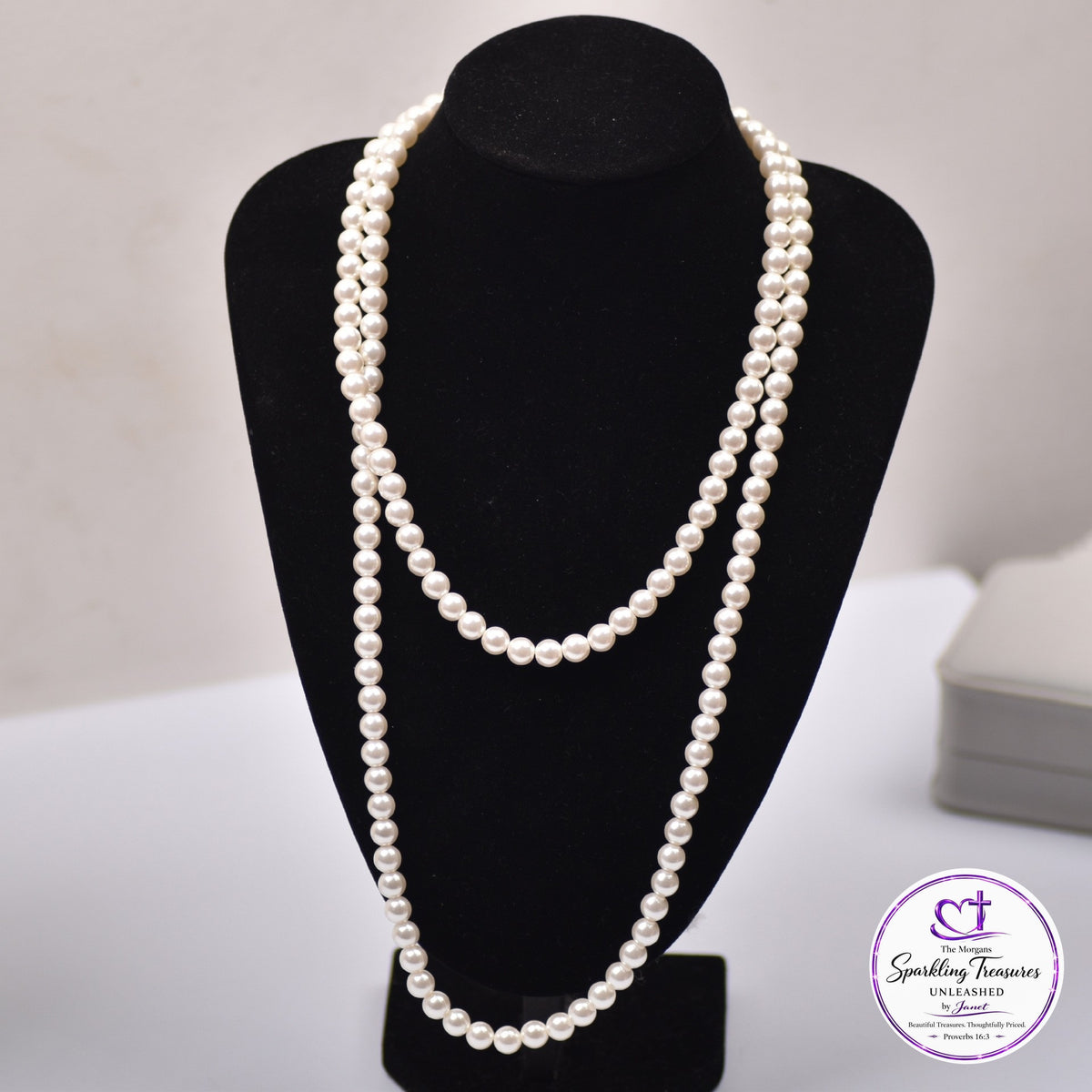 A double-strand pearl necklace displayed on a black jewelry bust, with a Sparkling Fineries logo watermark in the bottom right corner.