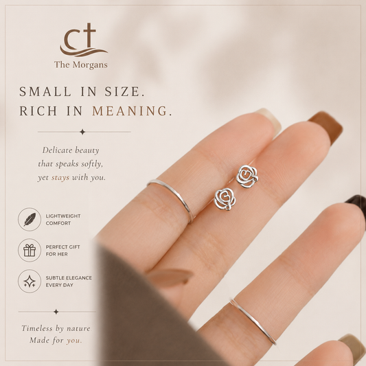 Silver rose-shaped earrings on a finger with The Morgans branding and product description.
