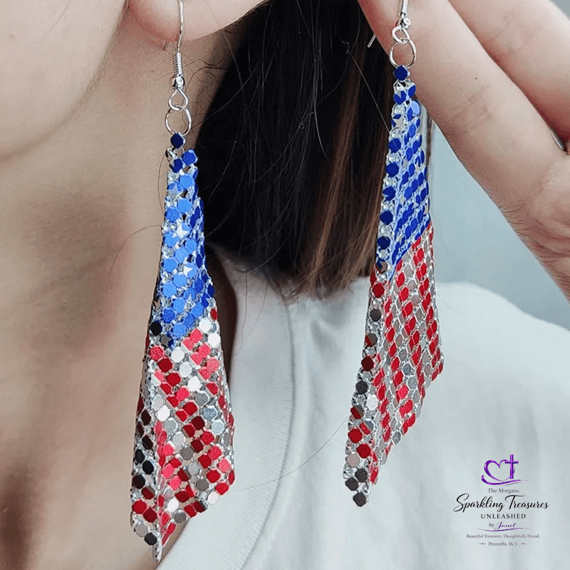 Earrings with blue, red, and silver pattern worn by a person against a neutral background.