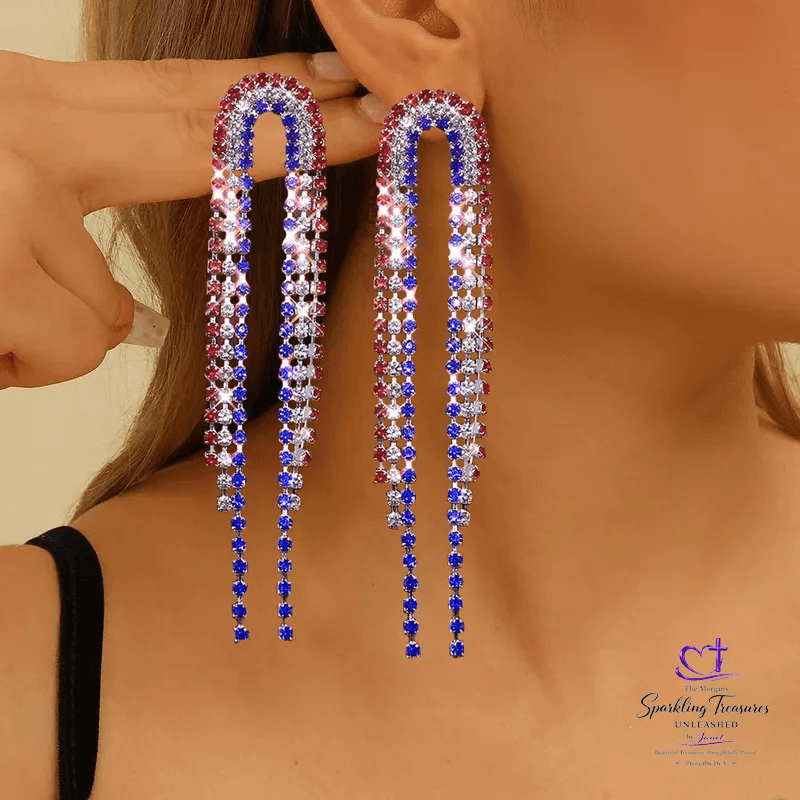 Long, colorful earrings being worn by a person with a neutral background