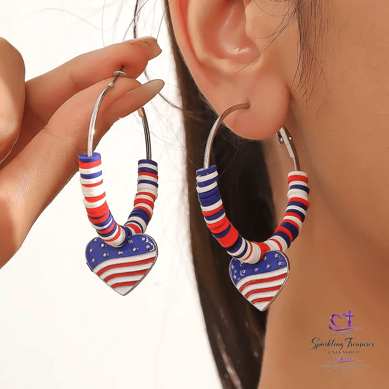 Heart-shaped earrings with red, white, and blue design worn by a person.