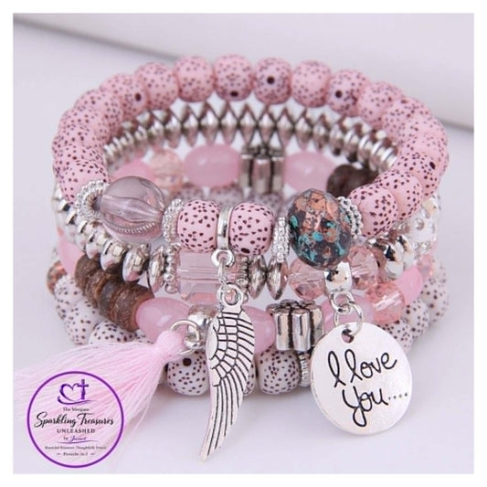 Stack of pink beaded bracelets with charms on a white background